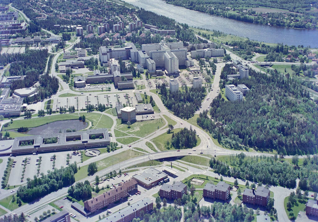 Ett flygbild av Universitetsområdet år 1991. Det erbjuder oss en helt annan möjlighet att få en djupare och mer detaljerad inblick i denna plats än vad vi normalt kan uppleva från marknivå.